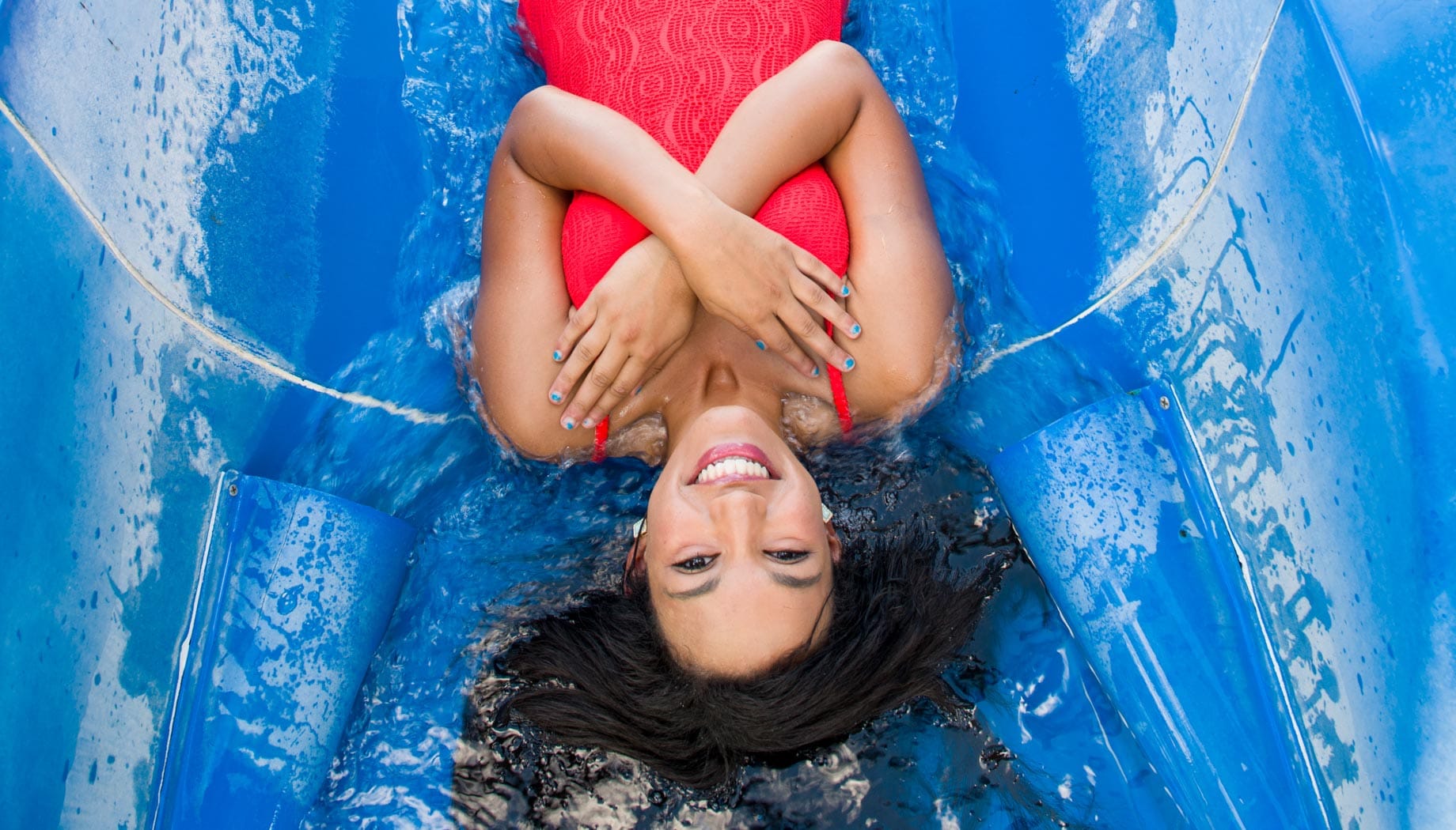 jet-stream-woman Woman in a red bathing suit with her hands across her chest and ready to go down a water slide.