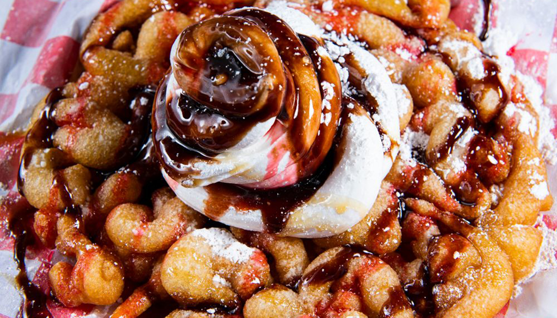 BLOG Funnel cake with strawberries, whipped cream, and chocolate drizzle.