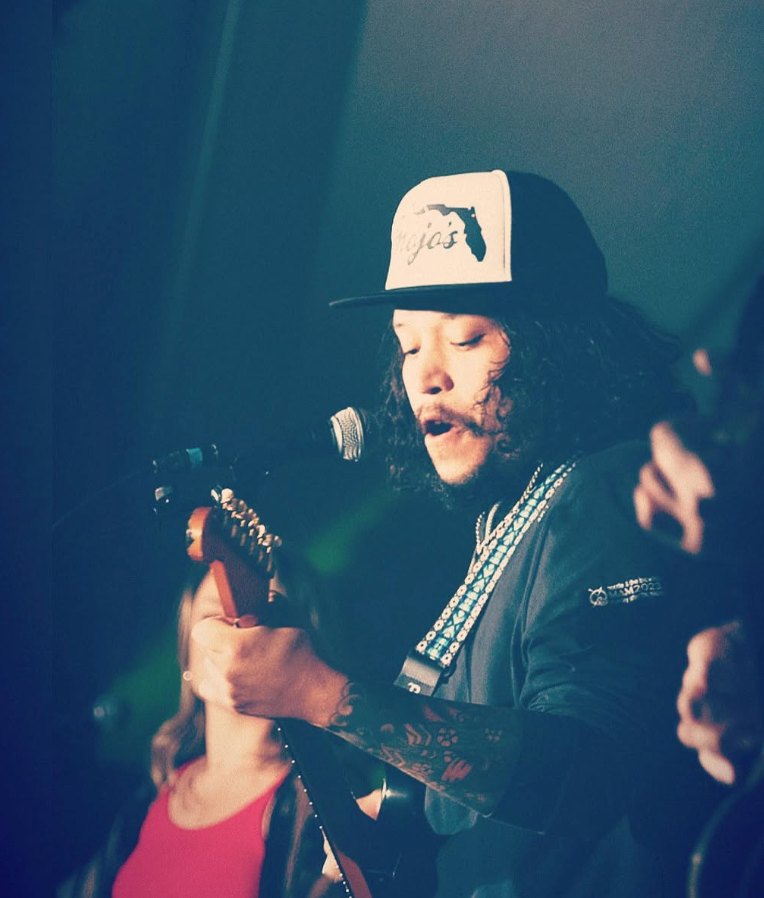 Preston Pohl singing and playing guitar on stage